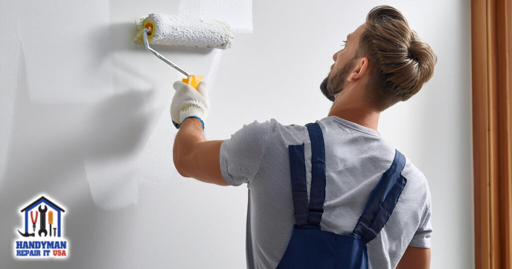 handyman applying fresh coat paint on wall with roller